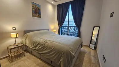 a bedroom with a bed and a large window at Apartment with terrace - Strategic location in Casablanca