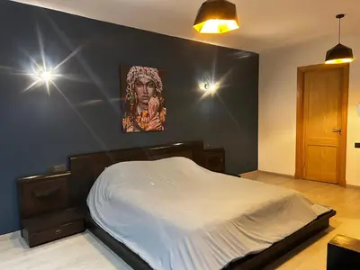 a bedroom with a bed with a painting on the wall at Chez vous au cœur de Casablanca in Casablanca