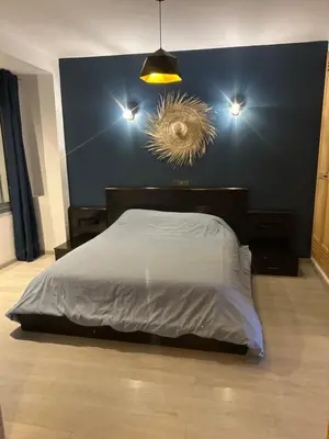 a bedroom with a bed with a blue wall at Chez vous au cœur de Casablanca in Casablanca