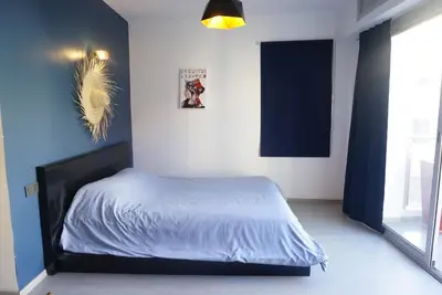 a bedroom with a bed with a blue accent wall at Chez vous au cœur de Casablanca in Casablanca