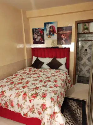 a bedroom with a large bed with a red headboard at Charming Moroccan apartment ground floor 2 bedrooms 1 living room in Casablanca