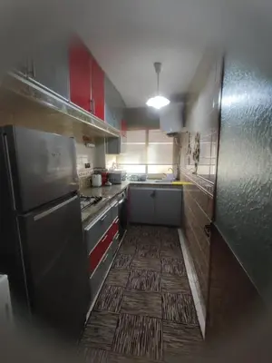 a small kitchen with red cabinets and a black refrigerator at Charming Moroccan apartment ground floor 2 bedrooms 1 living room in Casablanca