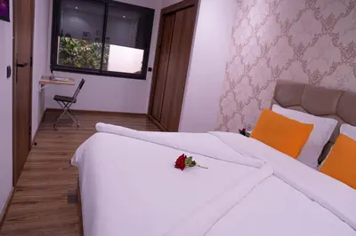 a bedroom with a white bed with a red flower on it at R103- Comfy and Spatious 1 BR Apartment with Breathtaking City View - Belvédère in Casablanca