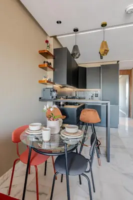 a kitchen with a glass table and chairs and a kitchen with a stove at VIVASTAY Casablanca - Carpdiem Aliya Residence in Casablanca