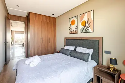 a bedroom with a large bed with white sheets at VIVASTAY Casablanca - Carpdiem Aliya Residence in Casablanca