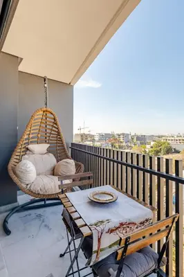 a porch with a swing and a table on a balcony at VIVASTAY Casablanca - Carpdiem Aliya Residence in Casablanca