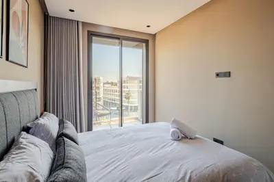 a bedroom with a bed and a large window at VIVASTAY Casablanca - Carpdiem Aliya Residence in Casablanca