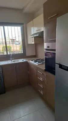 a kitchen with a sink and a stove top oven at Bel appartement familial résidence sécurisée in Casablanca