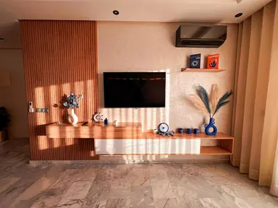 a living room with a flat screen tv on a wall at Appartement Vue Mer & Coucher de Soleil in Aïn Harrouda