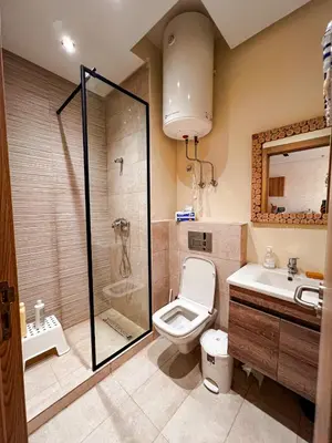 a bathroom with a shower and a toilet and a sink at Appartement Vue Mer & Coucher de Soleil in Aïn Harrouda