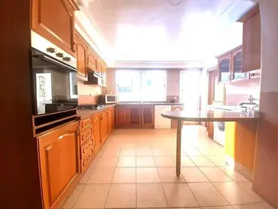 a kitchen with wooden cabinets and a table in it at Appartement 380M BD El Massira Maarif in Casablanca