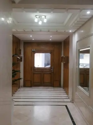 a hallway with a wooden door and a window at Appartement 380M BD El Massira Maarif in Casablanca