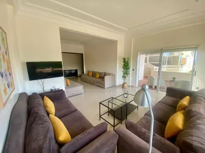 a large living room with a brown couch and yellow pillows at Appartement Vue Panoramique sur la siesta plage WELCOME STAY in Mohammedia