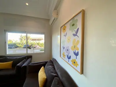 a living room with couches and a painting on the wall at Appartement Vue Panoramique sur la siesta plage WELCOME STAY in Mohammedia