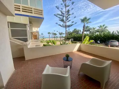a balcony with two chairs and a view of the ocean at Appartement Vue Panoramique sur la siesta plage WELCOME STAY in Mohammedia