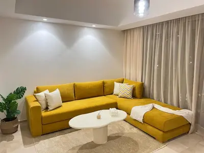 a living room with a yellow couch and a table at Sunshine Apartment in Casablanca