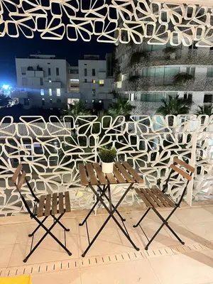 a table and two chairs in front of a wall at Sunshine Apartment in Casablanca