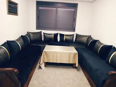 a living room with a couch with a table at Logement cozy in Oulad Kerroum