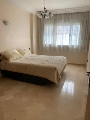 a bedroom with a bed and a large window at Quiet and spacious modern apartment near TGV station in Rabat