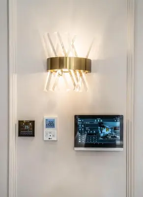 a gold light hanging on a wall with a clock at Contemporary apartment in CFC Anfa in Casablanca