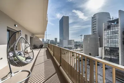 a hammock on a balcony with a view of a city at Contemporary apartment in CFC Anfa in Casablanca