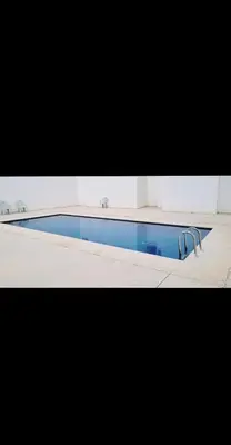 a swimming pool with blue water in a room at Luxurious space in Oulad Kerroum
