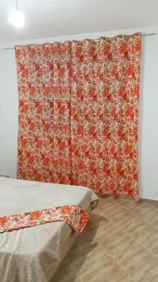 a room with two beds and a red curtain at Luxurious space in Oulad Kerroum