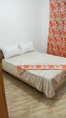 a bed in a room with a red and white curtain at Luxurious space in Oulad Kerroum