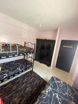 a bedroom with two bunk beds and a black cabinet at Appartement confortable et ensoleillée in Aïn Harrouda