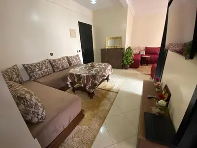 a living room with a couch and a table at Appartement confortable et ensoleillée in Aïn Harrouda