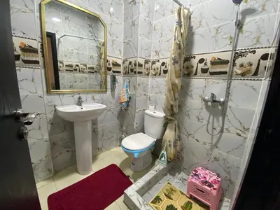 a bathroom with a sink and a toilet and a mirror at Appartement confortable et ensoleillée in Aïn Harrouda