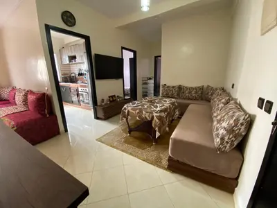 a living room with a couch and a table at Appartement confortable et ensoleillée in Aïn Harrouda