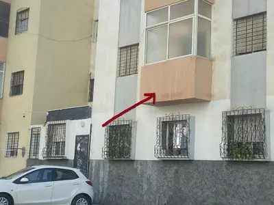 a white car parked in front of a building at Appartement confortable et ensoleillée in Aïn Harrouda