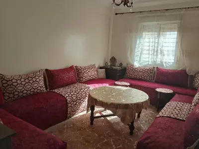 a living room with a couch and a table at Appartement confortable et ensoleillée in Aïn Harrouda