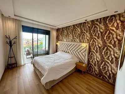 a bedroom with a bed and a wall with a pattern at Condo beach view in Casablanca in Casablanca