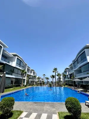 a swimming pool in front of some apartment buildings at Condo beach view in Casablanca in Casablanca