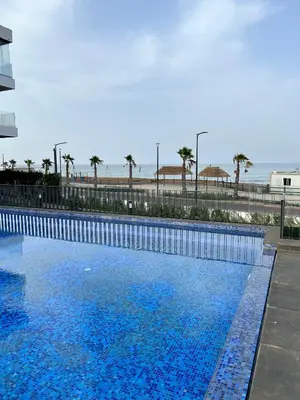 a large blue swimming pool next to the beach at Condo beach view in Casablanca in Casablanca