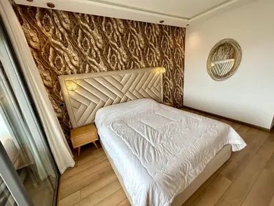 a bedroom with a white bed and a wall at Condo beach view in Casablanca in Casablanca
