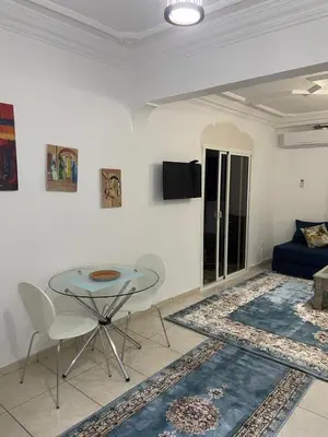 a living room with a glass table and a couch at Un petit studio in Settat