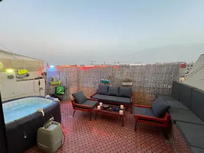 a rooftop patio with a hot tub and furniture at Appartement Agdal in Rabat