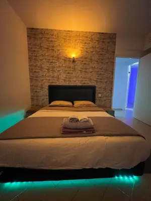 a bedroom with a large bed with a brick wall at Appartement Agdal in Rabat