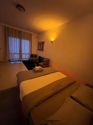 a hotel room with two beds and a living room at Appartement Agdal in Rabat