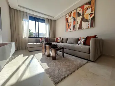 a living room with a couch and a table at Emplacement Central & Lumineux au Coeur De Casablanca Près Du Tramway 1 minute du Bd Abdelmoumen Maarif et 5 Minutes de Bab Marrakech et Centre Ville in Casablanca