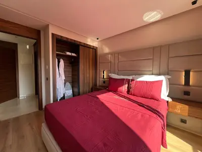 a bedroom with a large bed with red sheets and pillows at Emplacement Central & Lumineux au Coeur De Casablanca Près Du Tramway 1 minute du Bd Abdelmoumen Maarif et 5 Minutes de Bab Marrakech et Centre Ville in Casablanca
