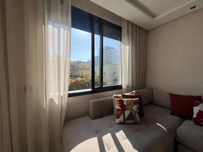 a living room with a couch and a large window at Emplacement Central & Lumineux au Coeur De Casablanca Près Du Tramway 1 minute du Bd Abdelmoumen Maarif et 5 Minutes de Bab Marrakech et Centre Ville in Casablanca