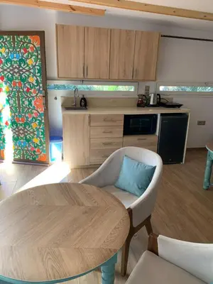 a living room with a table and a kitchen at Palmeraie 3 in Skhirat