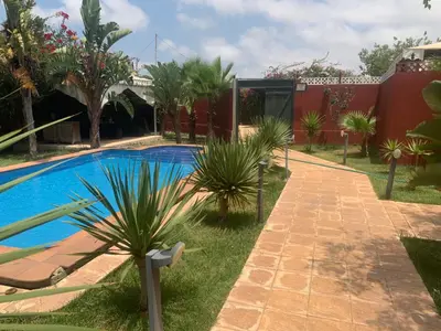 a resort with a swimming pool and palm trees at Villa luxueuse à Skhirat Rabat in Skhirat