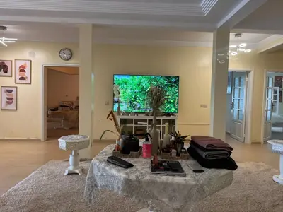 a living room with a table and a flat screen tv at Villa luxueuse à Skhirat Rabat in Skhirat