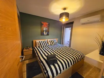 a bedroom with a black and white striped bed at Luxe & Confort in Cité de Bournazel