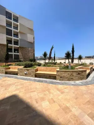 a courtyard with benches and a building with palm trees at Luxe & Confort in Cité de Bournazel